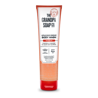 A tube of Apple Cider Vinegar Body Wash, with organic apple cider vinegar for glowing skin. The white and orange pack uses recycled content and highlights its vegan, cruelty-free, and purifying features.